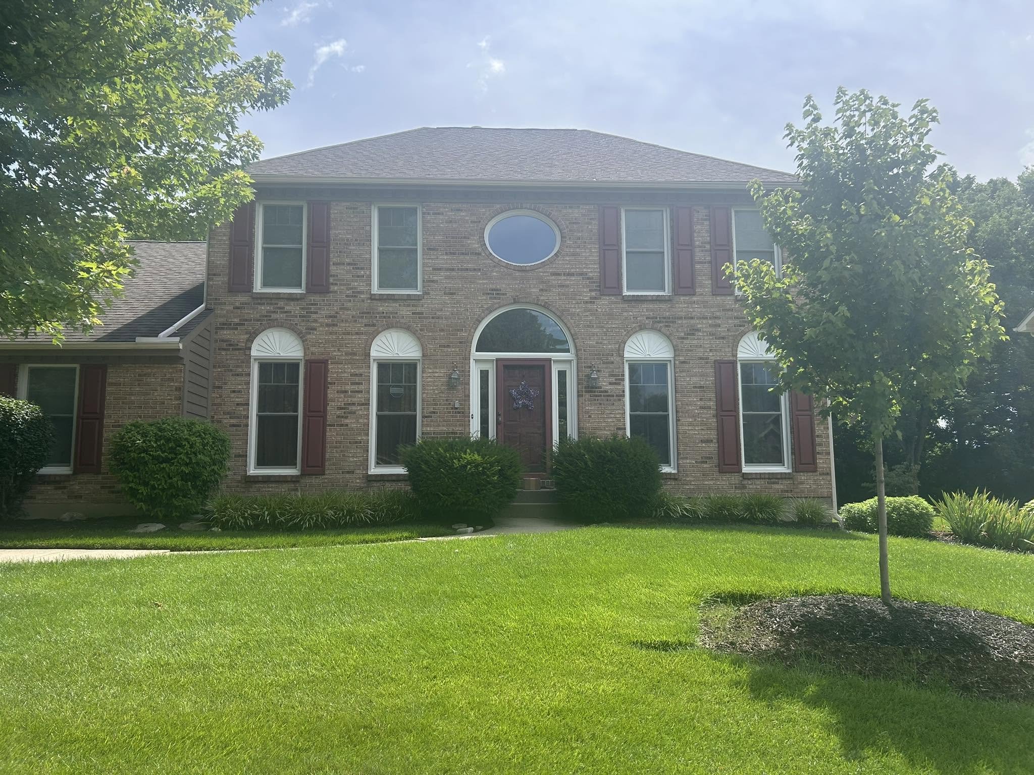 Before — formal two-story brick house without pool